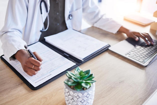 Dokterhandenverzekering en schrijven aan het bureau typen en laptop voor rapportresultaten of ideeën voor de gezondheidszorg Medicboek en pen voor naleving van papierwerk en info in notitieboekje per computer in het ziekenhuis