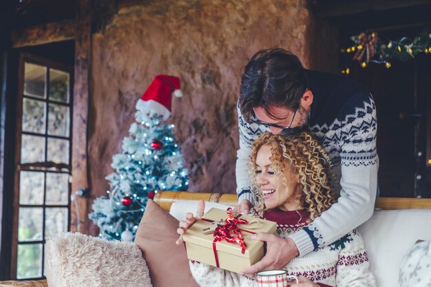 Dolblije vrouw thuis geniet van kerstcadeau van haar man