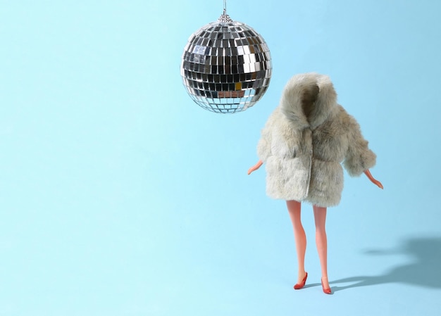 Doll in fur coat and disco ball on a blue background Party Concept art