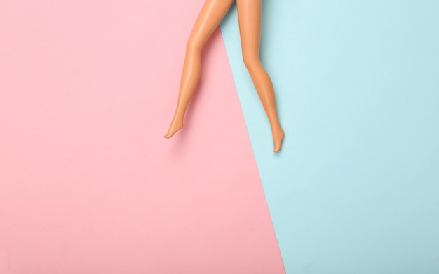 Doll vrouwelijke blote voeten op een blauwroze pastel achtergrond Creatieve minimalistische lay-out