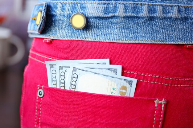 Dollar banknotes in jeans pocket closeup