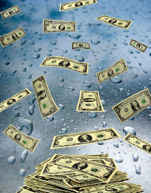 Dollar banknotes lying on the wet glass with drops