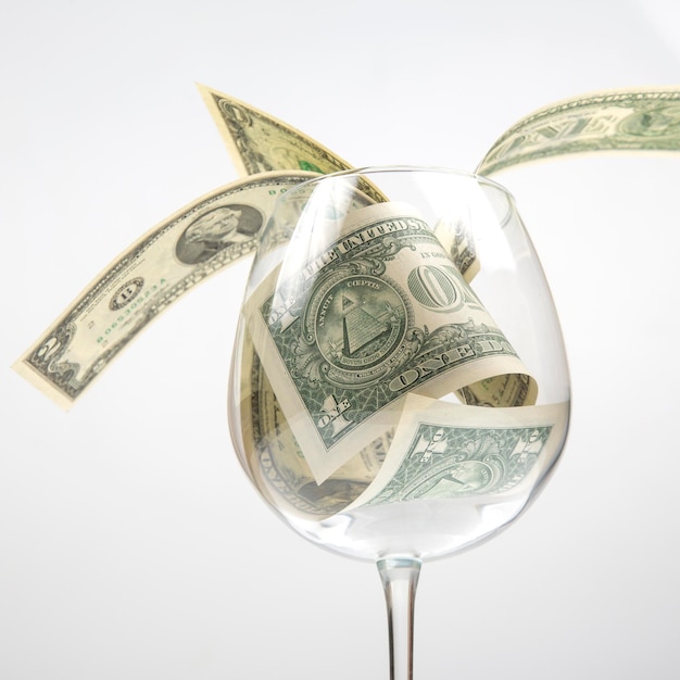 Dollar banknotes money lies in an empty wine glass business in the wine industry alcohol marketing