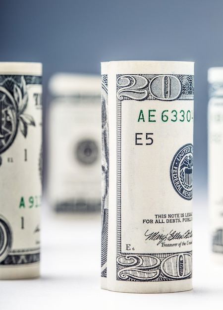 Dollar banknotes roll in other positions American currency on white board and defocused background