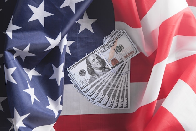 Dollar banknotes and USA national flag.