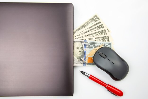 Dollar banknotes on a white background next to a laptop Online business sale Financial business success