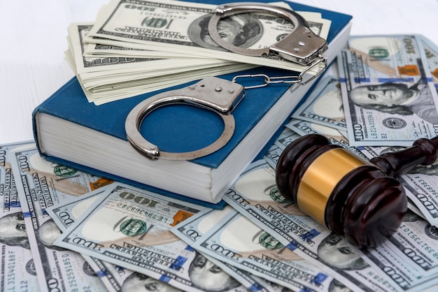 Dollar banknotes with handcuffs on blue book