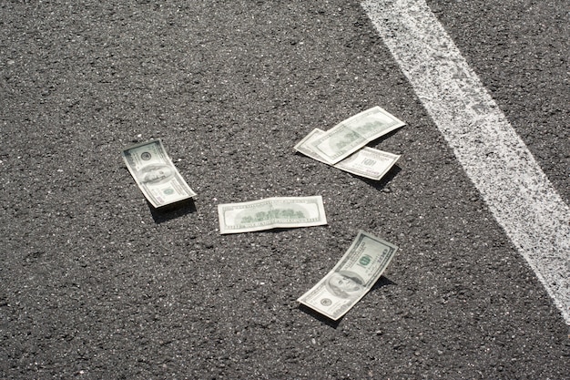 Photo dollar bills on asphalt road