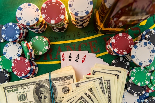 ドル札、カジノチップ、テーブルの上のウイスキーグラス。ギャンブルゲームとエンターテイメントのコンセプト。