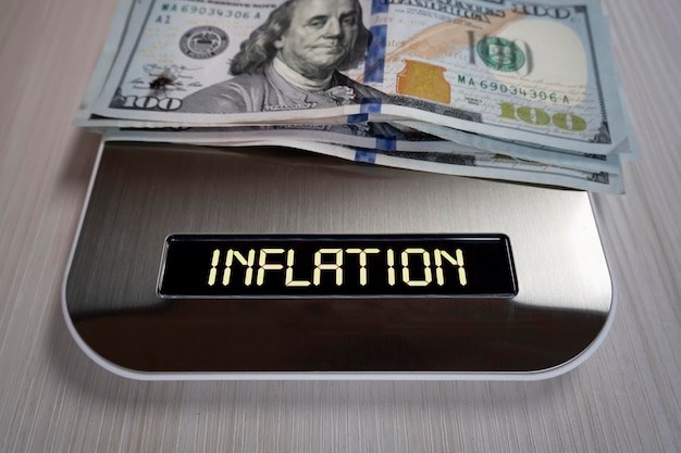 Долларовые купюры на электронных весах - символ снижения затрат, инфляции, обесценивания денег, концепции инфляции в Соединенных Штатах Америки.