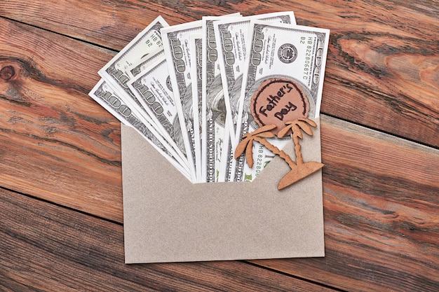 Dollar bills in envelope. Greeting card on Father's Day. Relaxation on vacation.