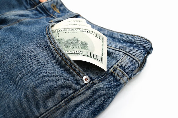 Dollar bills in the front pocket of jeans, on an isolated white background . High quality photo