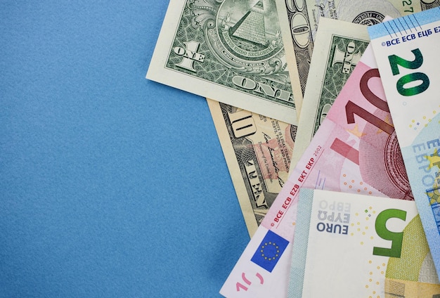 Dollar and euro banknotes on a blue background closeup