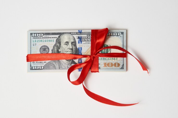 Dollar geld met rood lint op witte achtergrond met kopie ruimte. Geld cadeau