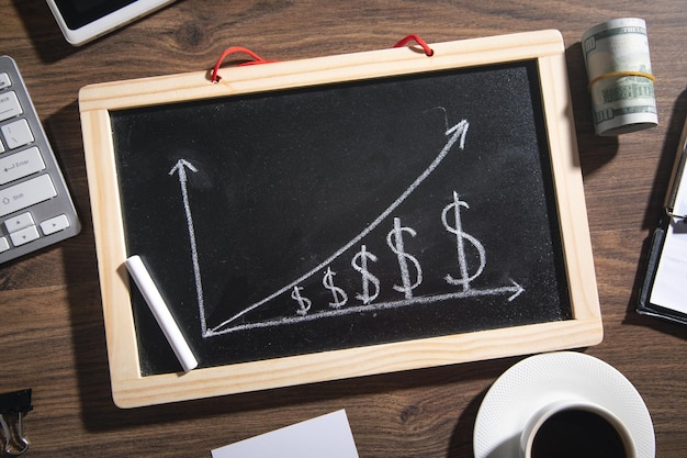 Dollar growth chart on blackboard with a business objects