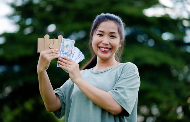 Dollar in the hands of an Asian woman Savings Investments Salary Income Cash Flow Happiness and Financial Success and Investments