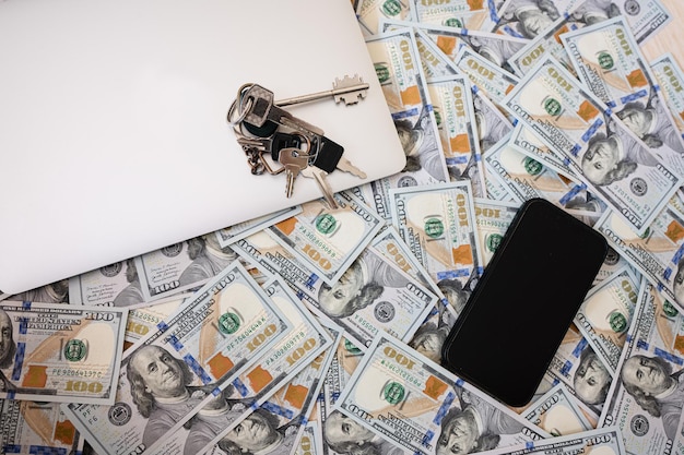 Долларовые деньги с ключами ноутбук и фон телефона