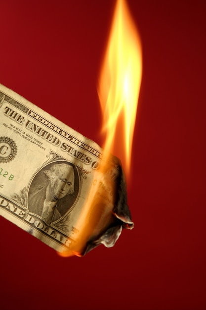 Фото Долларовая банкнота горит в огне над красным