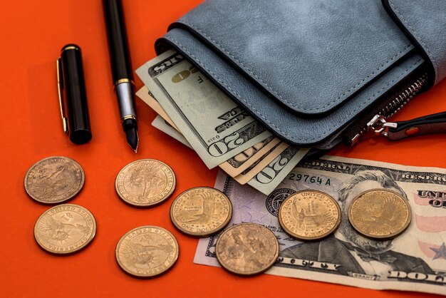 A dollar purse, coins and a pen