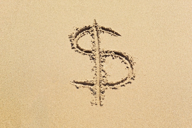 Dollar sign in the sand Expensive vacation concept