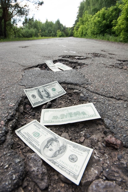 Dollarbiljetten in de kuilen op weg