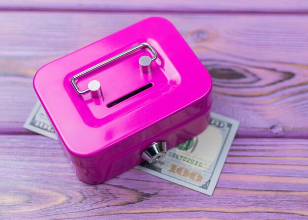 Dollars and a bank for money piggy bank on a wooden background