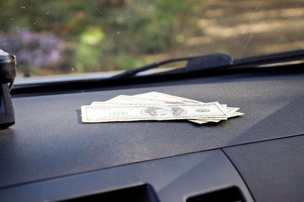 Dollars on a car dashboard under the windshield American Money