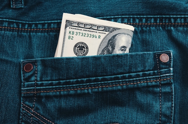 Dollari in contanti in una tasca di jeans blu.