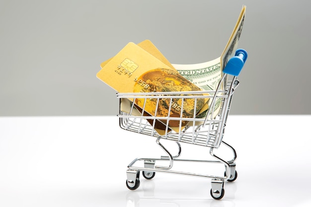 Dollars credit card and grocery cart Shopping in a supermarket Business sale Payment by terminal