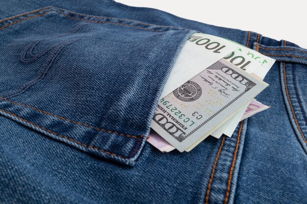 Dollars and euro sticking out of jeans pocket