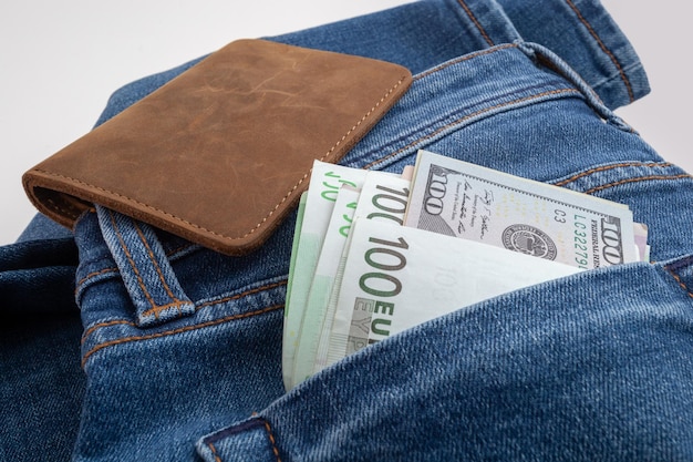 Dollars and euro sticking out of jeans pocket