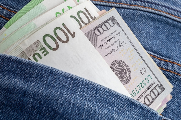 Доллары и евро, торчащие из кармана джинсов