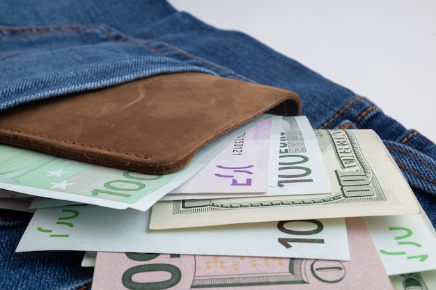 Foto dollari ed euro che spuntano dalla tasca dei jeans