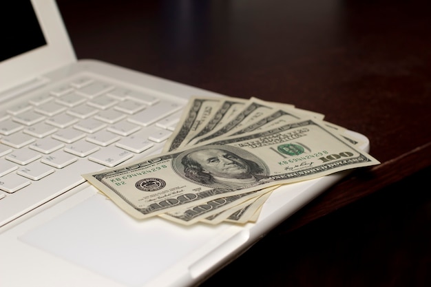 Dollars on a keyboard of notebook. Business concept