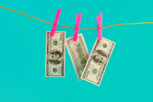 Dollars money on rope clothespin on blue background