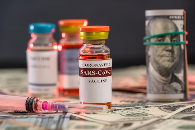 Dollars nieuwe mooie rekenmachine en getest vaccin tegen de kroon van het virus ligt op tafel Vaccinatieconcept tijdens een pandemie