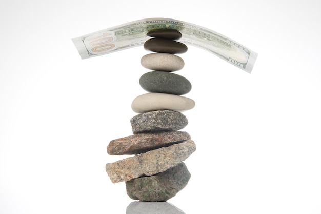 Dollars op een piramide van gladde stenen concept van balans en zakelijk succes in het leven