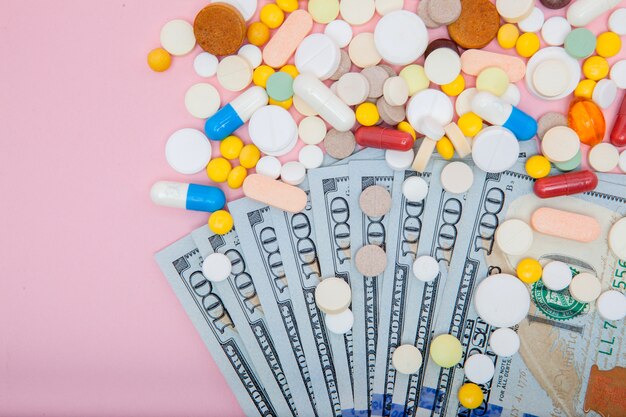 Photo dollars and pills on a pink background