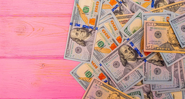 Dollars on a pink wooden background Money on the table American dollars
