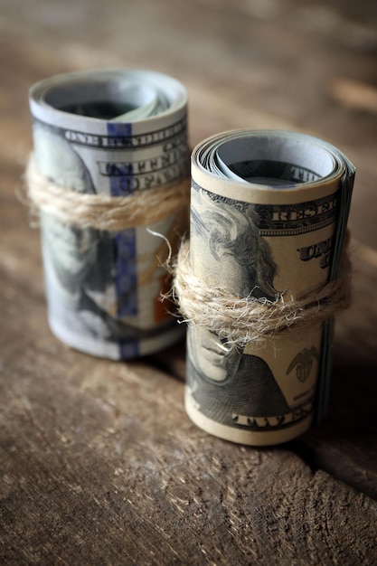 Dollars roll on wooden background