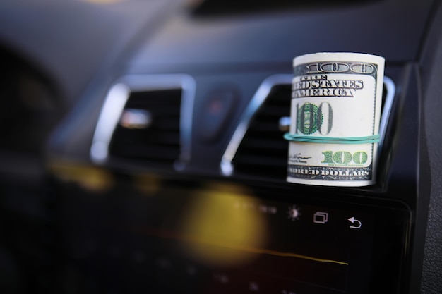 Dollars with a car key lie in inside cars financial\
concept