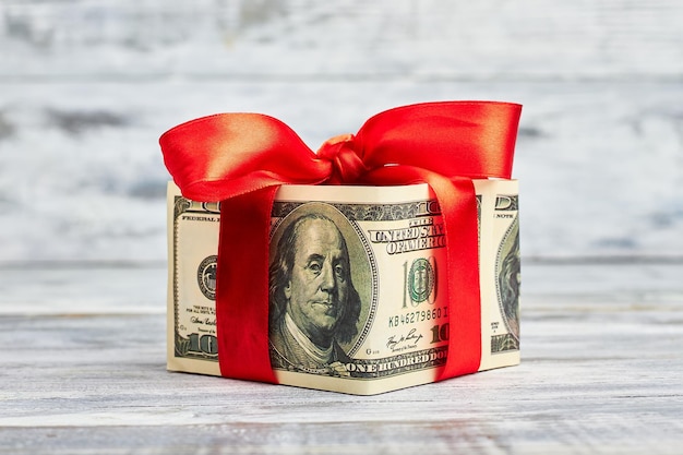 Dollars wrapped by red bow