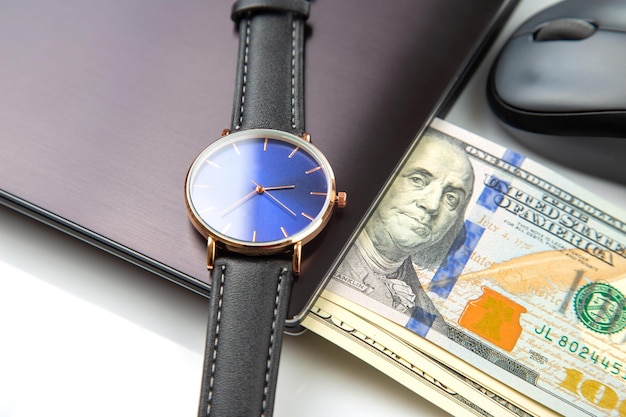 Dollars wristwatch near laptop with mouse Business online Working time for working with laptop