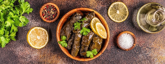 Dolma, stuffed grape leaves with rice and meat on dark background, top view.