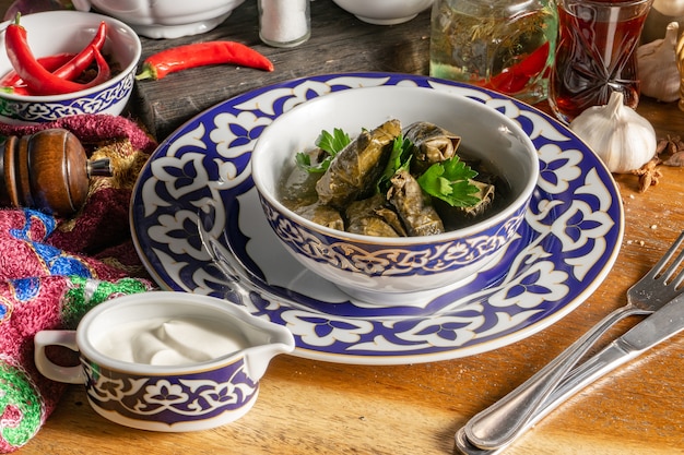Dolma. piatto caldo orientale tradizionale di agnello tritato in foglie di vite in salamoia con salsa matzoni all'aglio