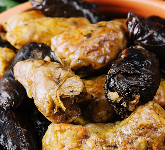 Dolma with meat rice in grape leaves in a clay pot