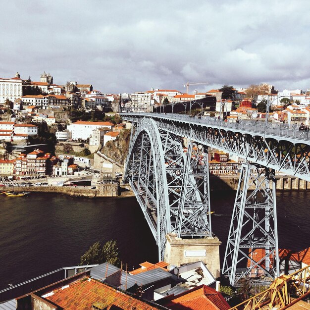 Photo dom luis i bridge over river amidst town against cloudy sky