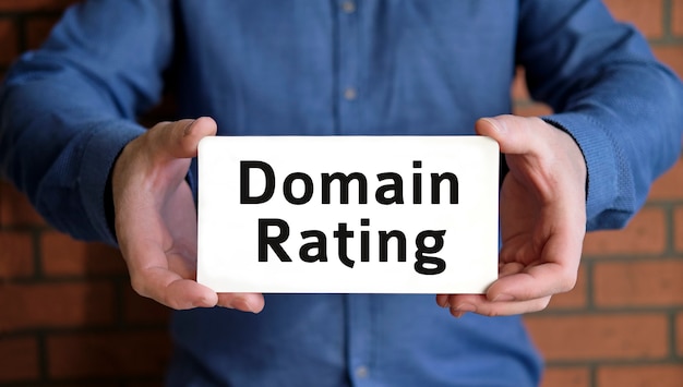 Domain rating - seo concept in the hands of a young man in a blue shirt