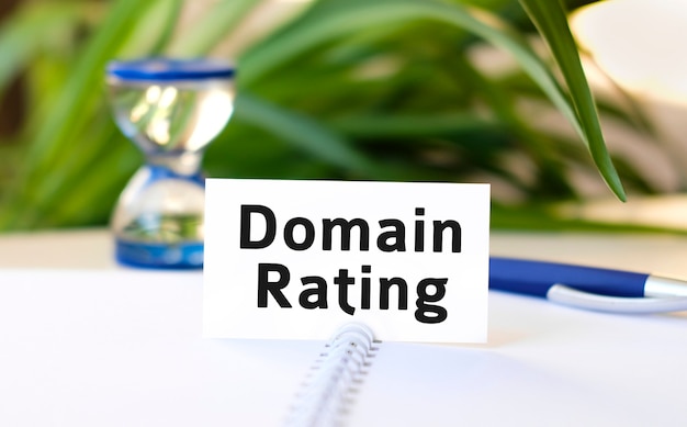 domain rating text on a white notebook and hourglass and blue pen