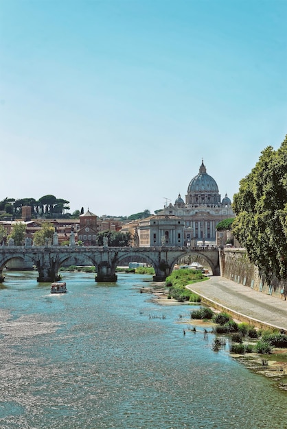 バチカン市国のサンピエトロ大聖堂のドームとイタリアのローマのテヴェレ川に架かるポンテサンアンジェロ橋。ハドリアヌス橋とも呼ばれます。ヴィンテージスタイルで特別に調色